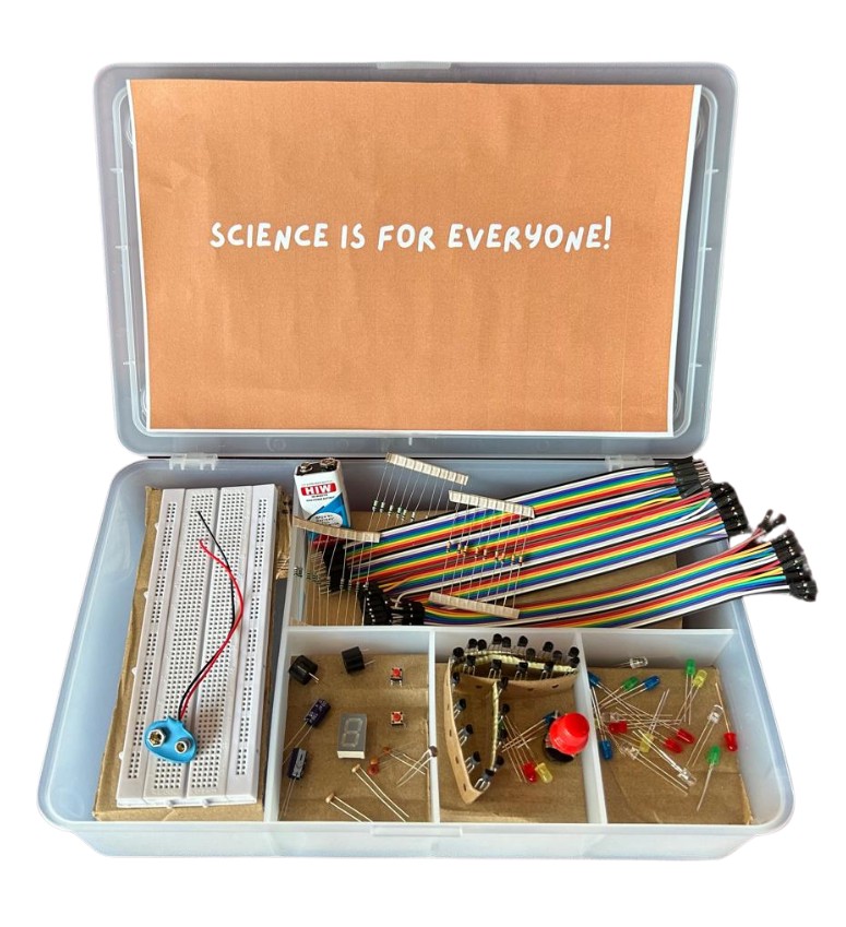 उड़ान Science Kit — open case with breadboard, battery, jumper wires, LEDs, resistors and electronic components
